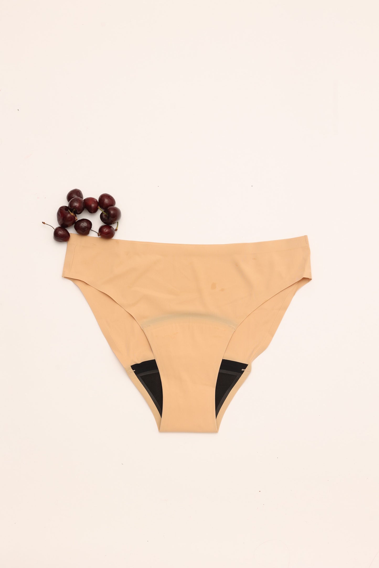 Flat lay of Cherrystain nude seamless bikini medium flow period underwear
